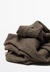 Brown folded woolen sweater with visible knit texture on a white background.