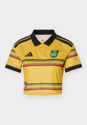 Sárga Jamaica Labdarúgó Szövetség mez fekete gallérral, fekete Adidas csíkokkal a vállakon és többszínű, vízszintes mintás szalagokkal.
