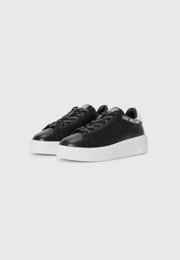 Zwarte leren sneakers met witte zool, ronde neus en decoratieve veters. Bevat "LOVE MOSCHINO" branding op de tong en zijkant.