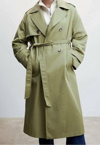 Olijfgroene trenchcoat van een katoenmix, met een dubbelgeknoopte sluiting, ceintuur in de taille, zijzakken en grote revers.