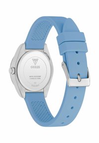 Relógio com correia de silicone azul e caixa de aço inoxidável. Mostrador redondo, resistente à água, textura suave e gravação do logotipo no verso.