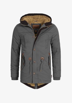Graue Jacke mit Kapuze, ausgestattet mit einem braunen Futter aus Fell, Holzknöpfen und mehreren Fronttaschen. Enthält eine Zugkordel und gerippte Bündchen.
