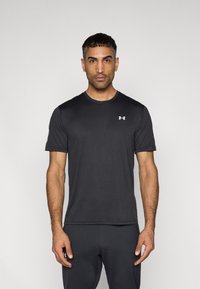 Μαύρο αθλητικό κοντομάνικο μπλουζάκι με στρογγυλή λαιμόκοψη, κατασκευασμένο από λεία ύφασμα. Διαθέτει μικρό λευκό λογότυπο στο επάνω αριστερό μέρος του στήθους.