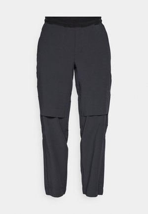 Pantaloni cargo tecnici neri con cintura elastica, dotati di molteplici tasche e una vestibilità affusolata. Realizzati in materiale leggero e flessibile.