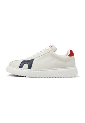 White leather sneaker with navy side detail, red heel tab, white laces, and thick white sole branded "Camper" on the side.