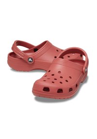 Rote Kunststoff-Clogs mit geschlossener Zehenpartie, offenem Rücken und mehreren Belüftungslöchern; mit strukturierten Griffflächen an der Sohle und dem Riemen.