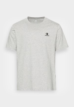 Jasnoszara koszulka z krótkim rękawem, okrągłym dekoltem, z czarnym logo Converse po lewej stronie klatki piersiowej.