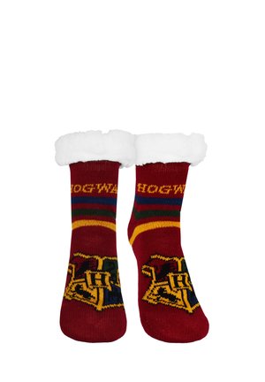 Rote Socken mit weißen, flauschigen Bündchen, die das Hogwarts-Wappen und einen Schriftzug zeigen, und darüber grüne, gelbe und blaue Streifen oberhalb des Knöchels.