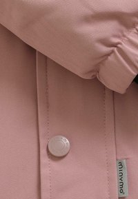 Roze visgraat stof shirt met een rond kraag, voorzien van een lichtgekleurde ronde knoop en een klein merketiket aan de zijkant.