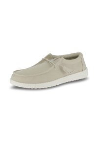 Scarpe in canvas beige chiaro con tomaia texturizzata, lacci elastici e suola bianca maculata. Punta arrotondata e design minimalista.