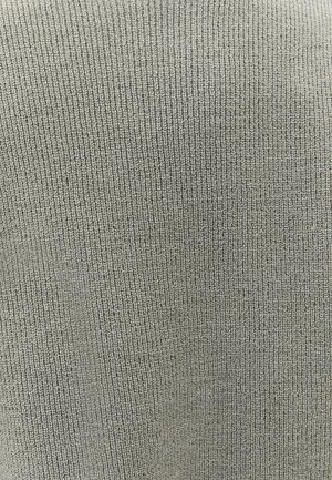 Gros plan sur un tissu en maille côtelée gris clair montrant un motif de tricot vertical détaillé et une texture.