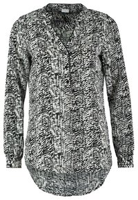 Blouse à manches longues à motifs abstraits en noir et blanc, avec col en V, patte de boutonnage à trois boutons et ourlet arrondi.