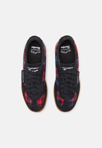 Snygga svarta sneakers med rutigt textil i röd, grön och blått, med svarta mockadetaljer, snörning och sula av gumm gummi.