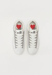 Valge nahast tossud halli nubukiga, valgete paeltega, mustriga "LOVE MOSCHINO" bränding ja punane südamekujuline sisetald.