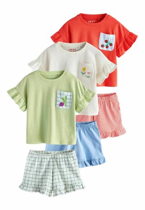 Trzy dziecięce bluzki z falbankami na rękawach w kolorach czerwonym, białym i zielonym z haftowanymi kieszeniami, połączone z pasującymi falbaniastymi szortami w paski i kratę.