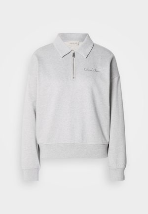 Ανοιχτό γκρι φούτερ με φερμουάρ στον γιακά, ριμπ μανσέτες και τελείωμα. Διαθέτει κεντημένο λογότυπο στην αριστερή πλευρά του στήθους. Απαλή υφή.