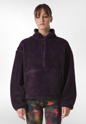 Purple fleece pullover with a high collar, half-zip front, and spacious front pocket. Features soft texture and oversized fit.