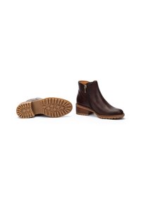 Botas de tobillo de cuero marrón con cremallera lateral, una suela de goma texturizada y un tacón bajo apilado, que presentan un diseño de puntera lisa y acentos mínimos.