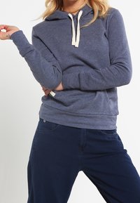 Marinblå huvtröja med ficka fram, elfenbensfärgade snören, långa ärmar och ribbade muddar, tillverkad av mjukt tyg.