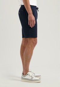 Shorts bleumarin cu un finisaj texturat, talie elastică și șnur de ajustare. Buzunare laterale și spate cu detaliu cu buton.