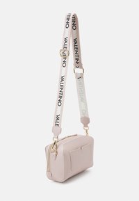 Borsa a tracolla in pelle rosa con dettagli in metallo dorato, finitura testurizzata e tracolla removibile con testo del logo nero. Dettaglio della tasca frontale incluso.