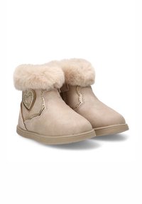 Botines beige con ribete de piel sintética, adorno en forma de corazón, parte superior texturizada y suela de goma flexible. Presentan detalles cosidos.
