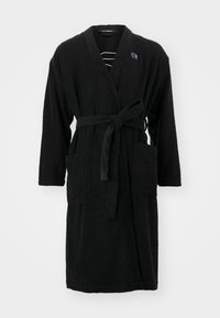 Robe de terry cloth preto com mangas longas, cintura atada e dois bolsos frontais. Apresenta um pequeno logótipo no peito e forro listrado.