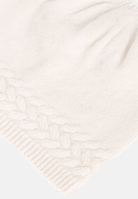 Dzianinowa czapka w jasnobeżowym kolorze z teksturowanym, plecionym wzorem wzdłuż brzegu i delikatnymi marszczeniami na czubku. Miękka, ciepła tkanina.