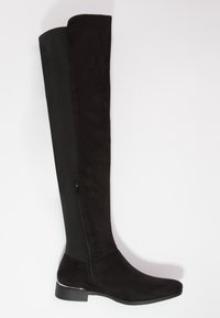 Bota negra de ante y tejido, plana, por encima de la rodilla, con cremallera lateral y tacón bajo.