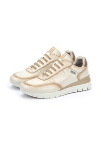 Baskets en cuir beige avec des accents texturés et une finition lisse. Design à lacets avec une semelle rembourrée et de légères touches métalliques.