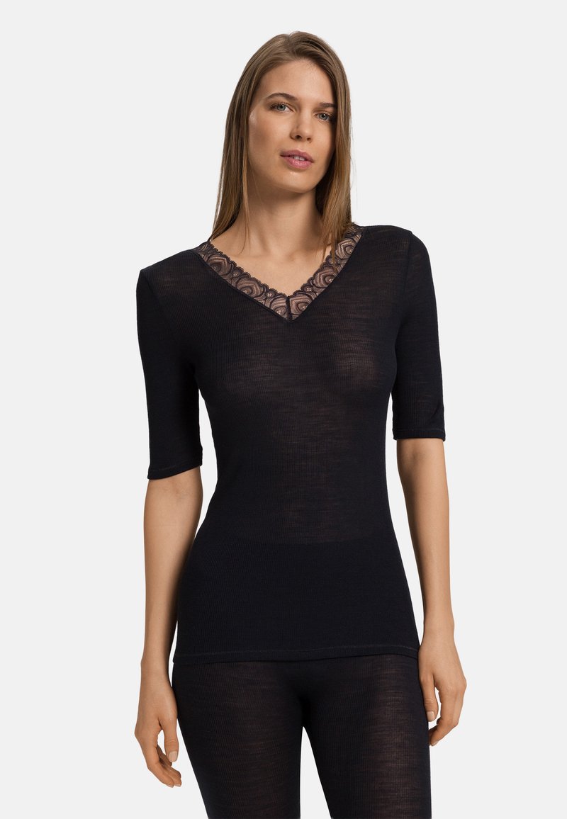 Top nero a V con maniche corte, caratterizzato da accenti in pizzo floreale trasparente sul colletto, realizzato in tessuto leggero e a coste.