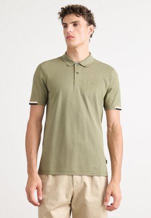 Khaki polo shirt with a flat collar, three-button placket, and short sleeves featuring striped accents at the cuffs. Soft texture.