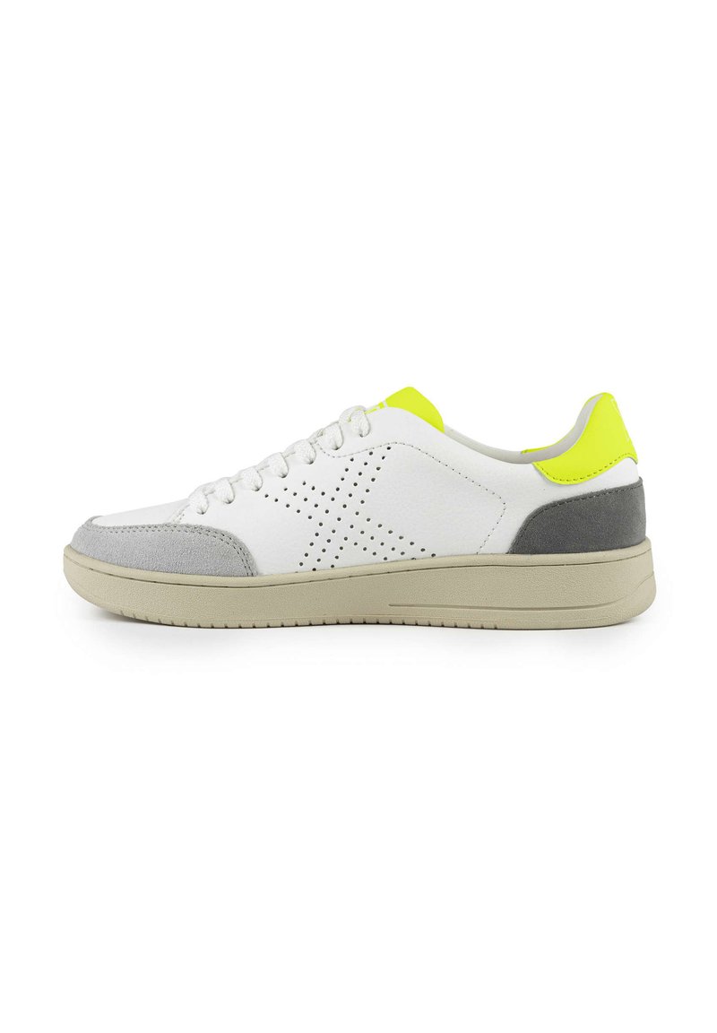 Sneaker bianco con tocchi in suede grigio sulla punta e sul tallone. Presenta un design perforato, un tessuto texturizzato e un tab in giallo brillante sul tallone.