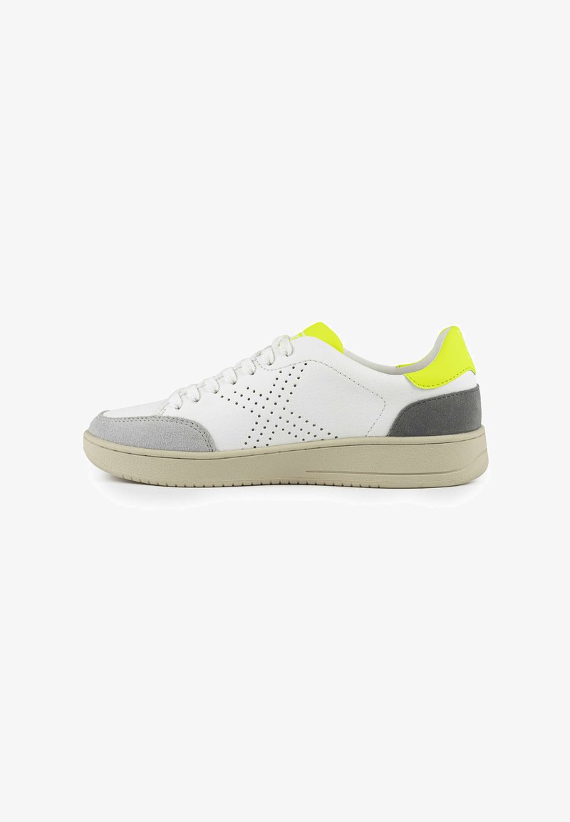 Sneaker bianco con tocchi in suede grigio sulla punta e sul tallone. Presenta un design perforato, un tessuto texturizzato e un tab in giallo brillante sul tallone.