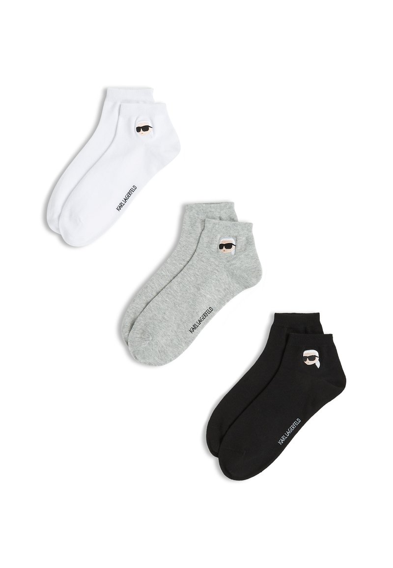 Tres pares de calcetines tobilleros en blanco, gris y negro. Cada uno cuenta con un gráfico de personaje y el nombre de la marca impreso en el lateral.
