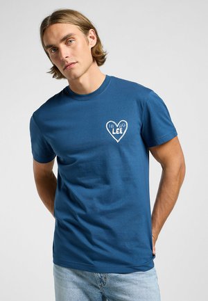 Blaues Baumwoll-T-Shirt mit einem weißen Herzen-Design und dem Text "LEE" und "1889". Kurze Ärmel und runder Halsausschnitt. Schlichte und lässige Passform.