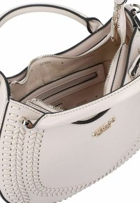 Borsa a tracolla in pelle rosa chiaro con dettagli neri, caratterizzata da un design cucito, chiusura a zip superiore e tasche interne. Dettagli in metallo dorato visibili.
