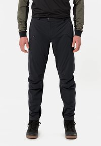 Pantalons noirs pour l'extérieur avec poches zippées, fabriqués à partir d'un matériau léger et flexible. Conçus pour le mouvement et le confort pendant les activités.
