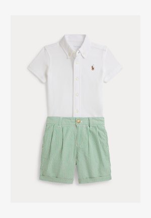 Polo bianca a maniche corte con chiusura a bottoni e logo ricamato; pantaloncini a righe verdi e bianche con pieghe e vita con bottoni.