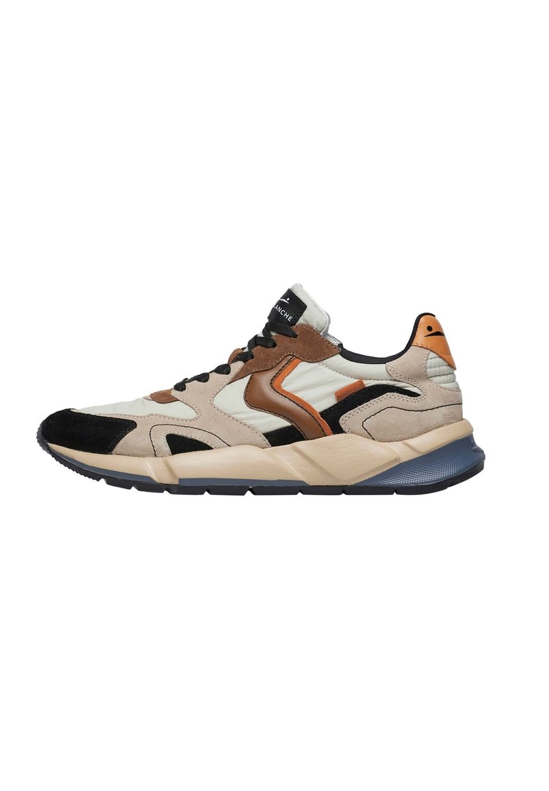 Sneakers con una combinazione di suede beige, marrone e nero; presentano una tomaia con motivo, suola in gomma e un accento arancione sul tallone.