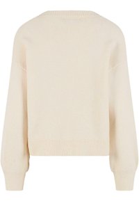 Krémový zkrácený svetr s jemnou texturou, raglánovými rukávy a žebrovanými manžetami a lemem. Jednoduchý design, žádné viditelné vzory nebo kovové prvky.