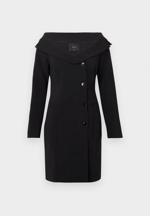 Črna obleka plašč z dolgimi rokavi, širokim ovratnikom in štirimi gumbi spredaj, krojena po meri z dvema žepoma na šivih, prikazana na belem ozadju.