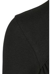 Czarny bawełniany t-shirt z okrągłym dekoltem i krótkimi rękawami, z prążkowaną fakturą oraz marszczeniami przy szwach na ramionach.