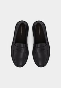 Ζευγάρι μαύρα δερμάτινα loafers Karl Lagerfeld χωρίς κορδόνια, με στρογγυλεμένες μύτες και λουράκια με λογότυπο στο πάνω μέρος, σε όψη από πάνω.