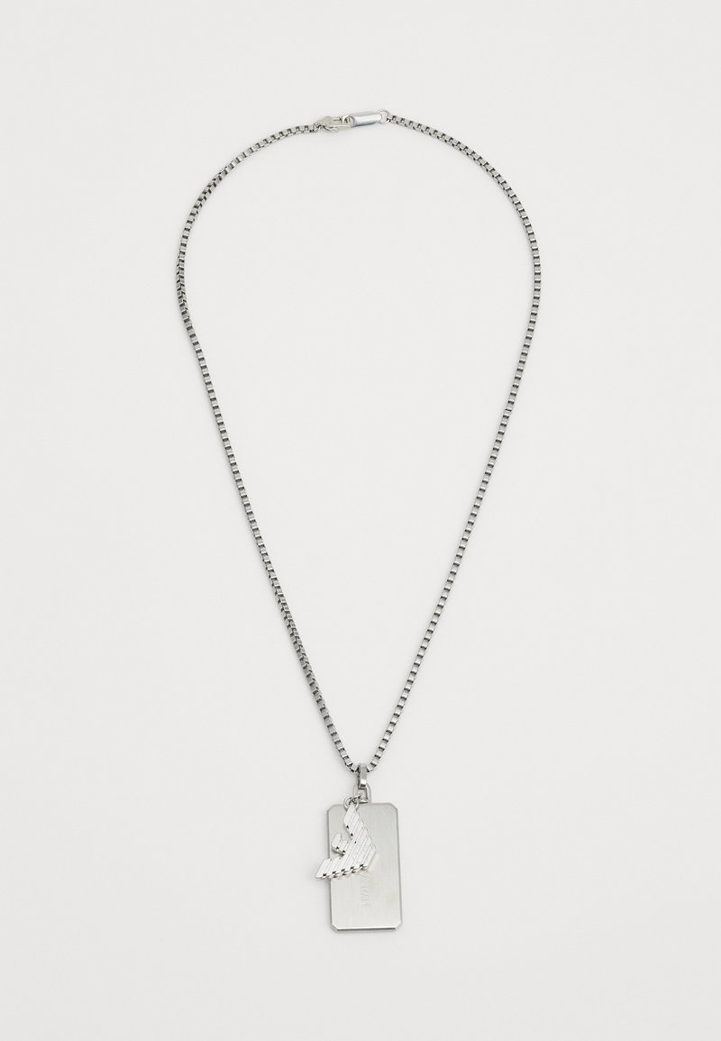 Strieborný náhrdelník s plochým obdĺžnikovým príveskom, ktorý má vyvýšený dizajn krídla. Reťaz je prepojená, čo vytvára jemný textúrovaný vzhľad.