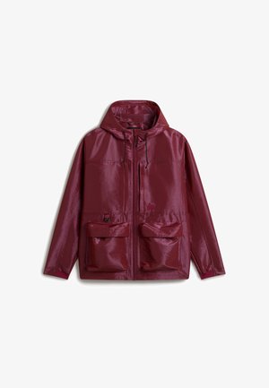 Giacca con cappuccio color marrone scuro con cerniera frontale, due grandi tasche con pattina, una tasca verticale con cerniera e coulisse regolabili sul cappuccio.