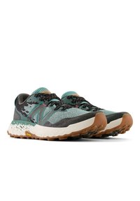 Trailrunning schoenen met een teal en grijze gebreide bovenkant, textiel stof, zwarte veters, en een robuuste witte tussenzool met een bruine loopzool.
