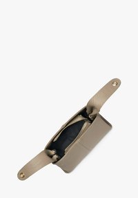 Bež torba od kože s teksturiranim završetkom, dva gornja ručka i unutrašnjost zatvorena patent zatvaračem; ima zlatne dodatke i crnu podstavu.