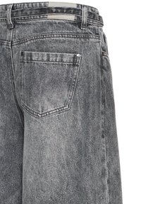 Vue arrière d'un jean en denim gris délavé avec une seule poche arrière ornée de rivets et des passants pour ceinture sur la taille.