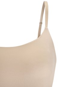 Beige seamless bralette met dunne verstelbare bandjes, een soepele textuur en een ronde halslijn, ontworpen voor een aansluitende pasvorm.